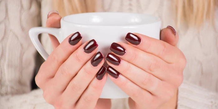 two hands, holding a coffee cup, burgundy red, nail polish, white sweater, cute nail colors, blonde hair