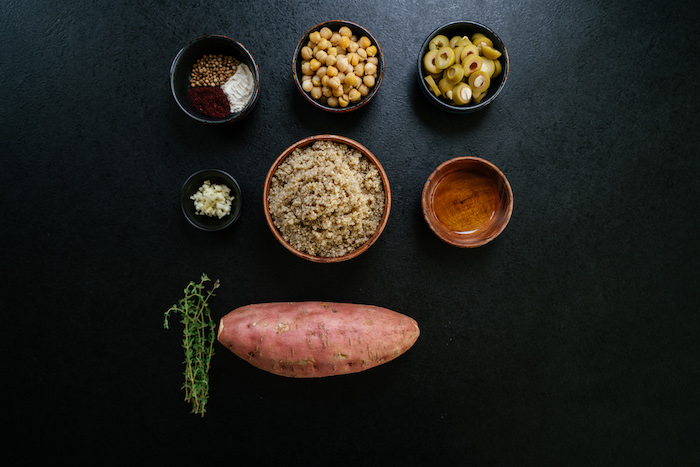 different bowls, with different ingredients, sweet potato, fresh thyme, arranged on black table, easy dinner recipes