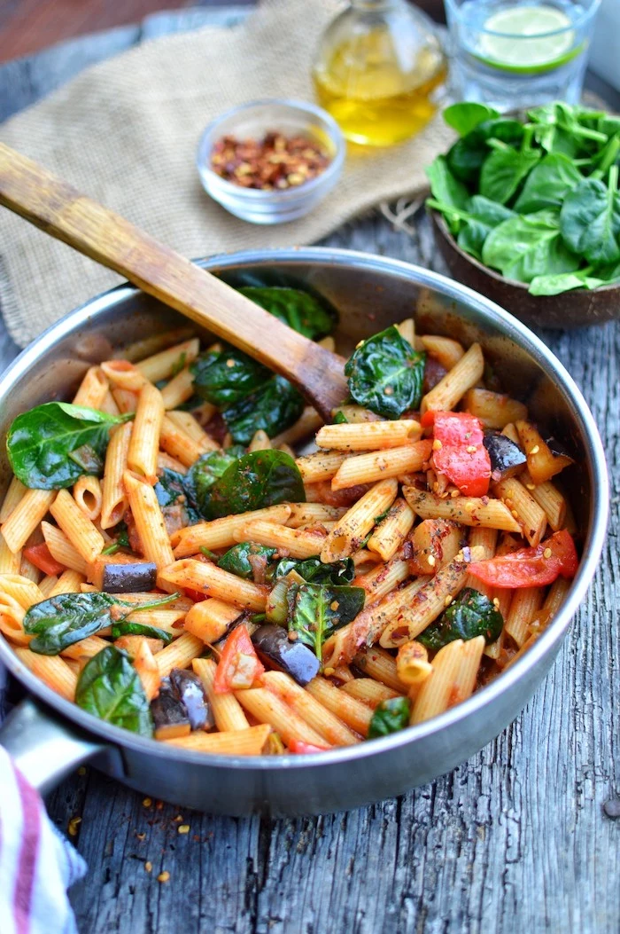 eggplant penne, with spinach and peppers, in a pot, wooden spatula, what to cook for dinner tonight easy, black wooden table