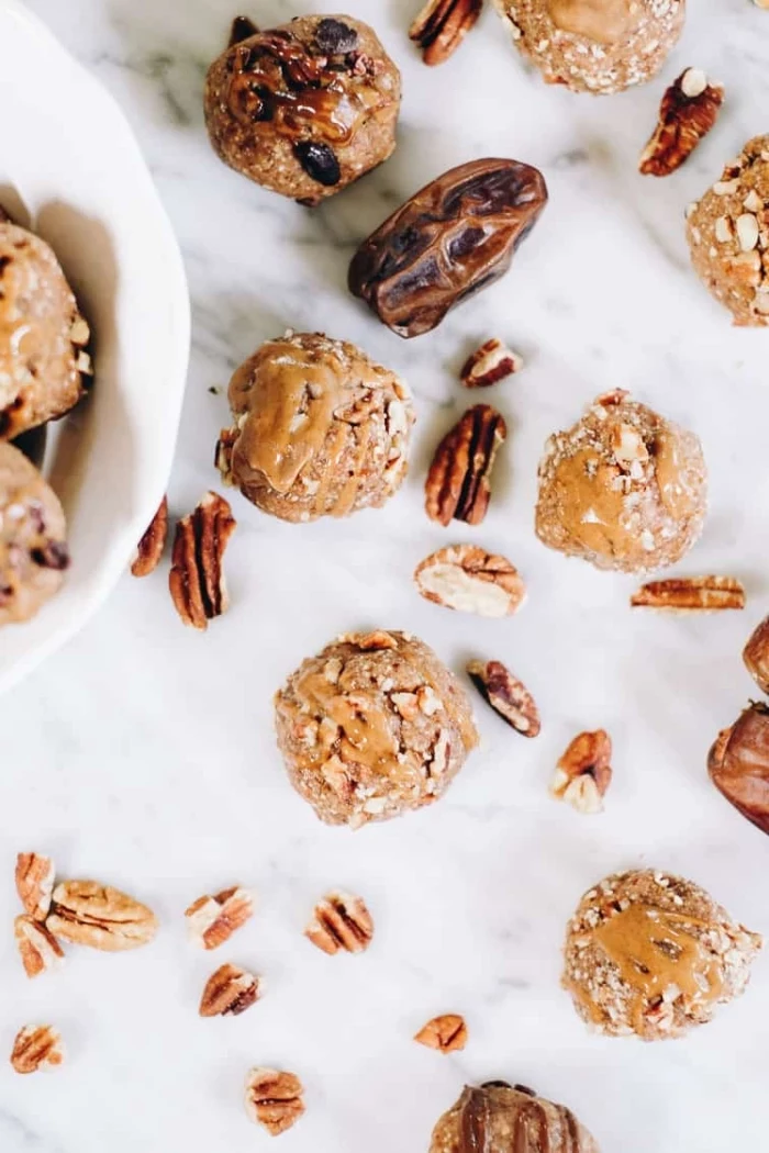dates and walnuts, scattered around the table, energy bites, with peanut butter drizzle on top