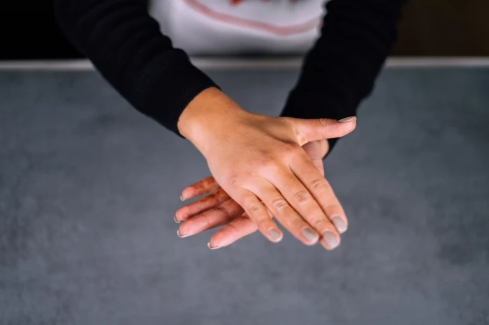 female hands, with grey nail polish, shaping chocolate mixture, energy balls, granite countertop