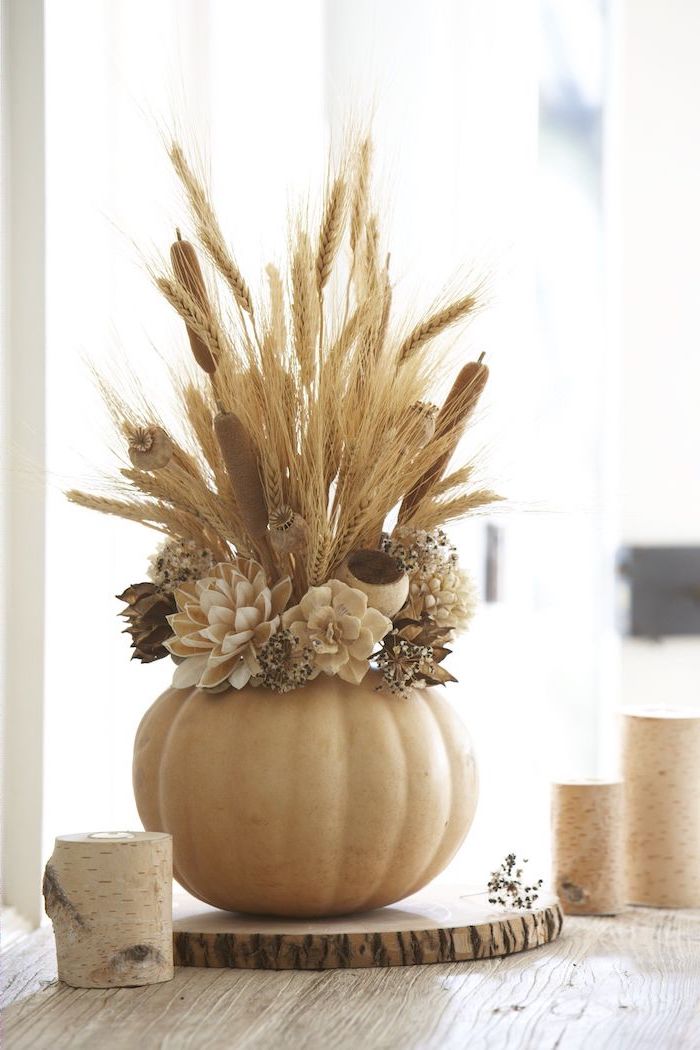 white pumpkin carved, faux flowers inside it, on wooden log, thanksgiving decorations diy, wooden table