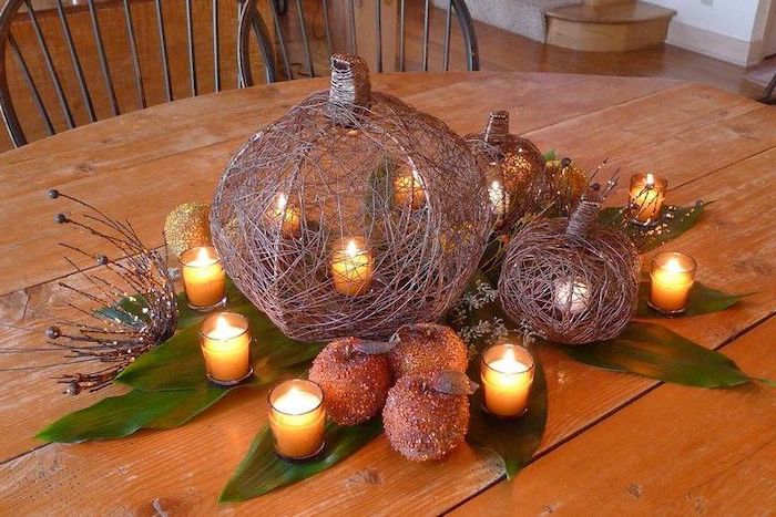 faux pumpkins, candles inside, candy apples, autumn decor, candles in glasses, wooden table