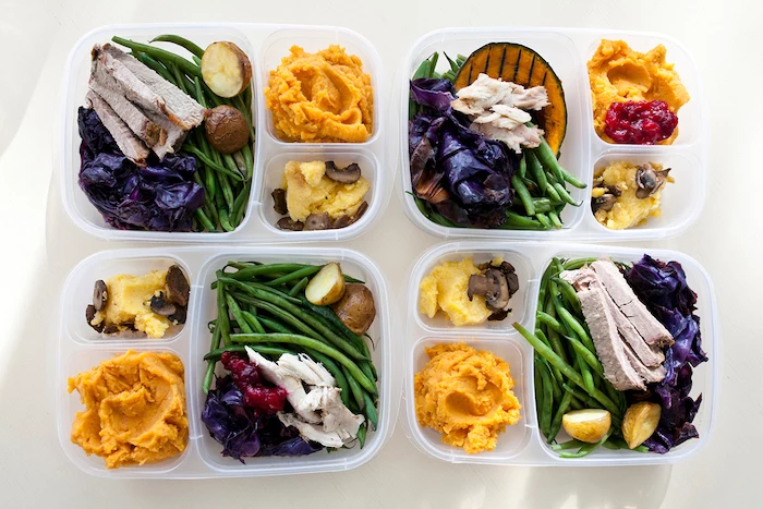 healthy meal prep ideas, four plastic containers, with meat and beans, butternut squash, cabbage and potatoes
