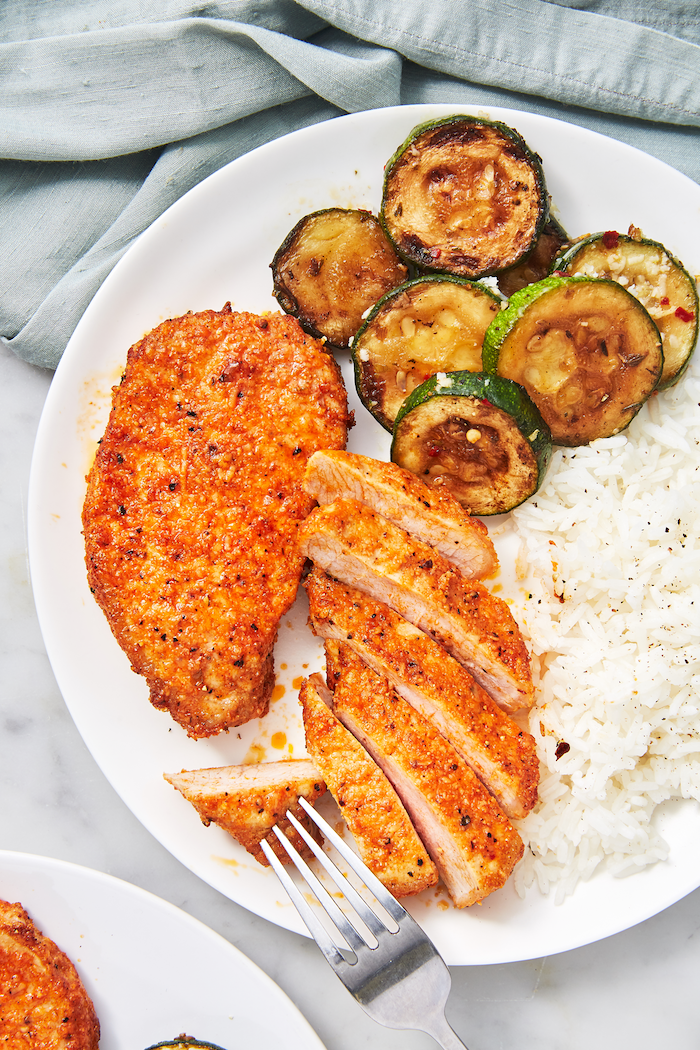 fried pork chops, cut into pieces, what's for dinner tonight, grilled zucchini, rice on the side, on white plate