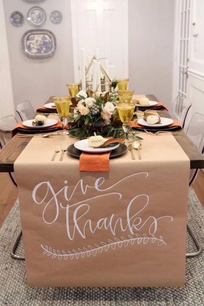 give thanks, table runner, outdoor thanksgiving decorations, yellow wine glasses, wooden table, plate settings, flower arrangement