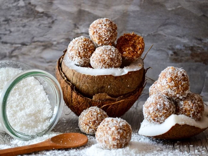 halved coconuts, power balls recipe, coconut flakes, in a glass jar, wooden spoon, peanut butter bites
