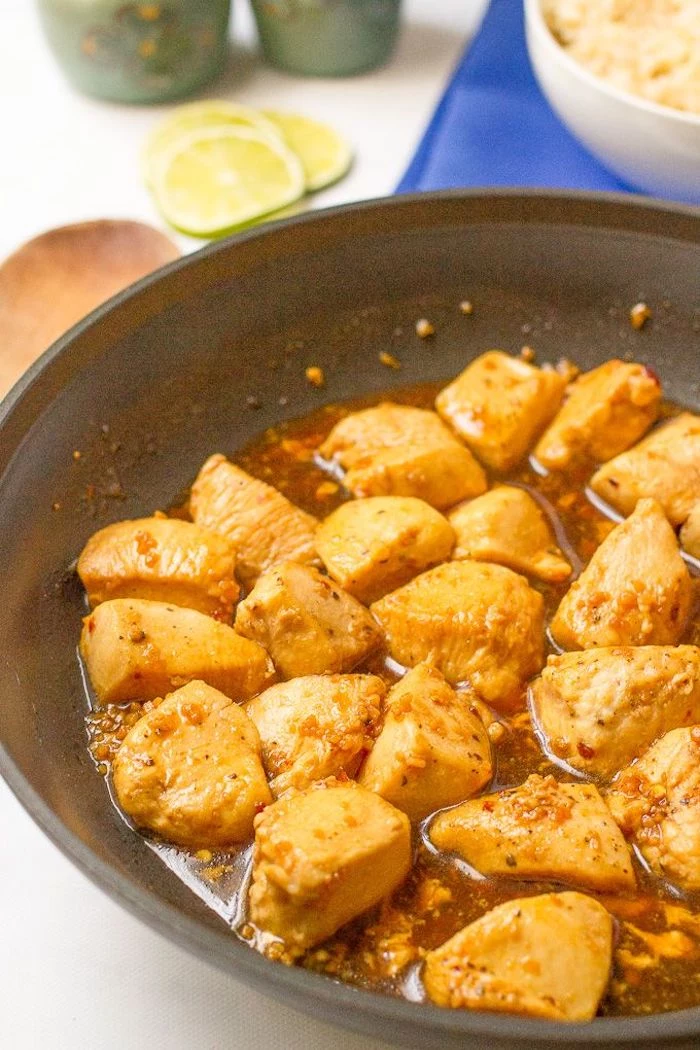 honey garlic chicken, cut into pieces, cooked in skillet, dinner ideas for tonight, lime slices, blue cloth, in the background