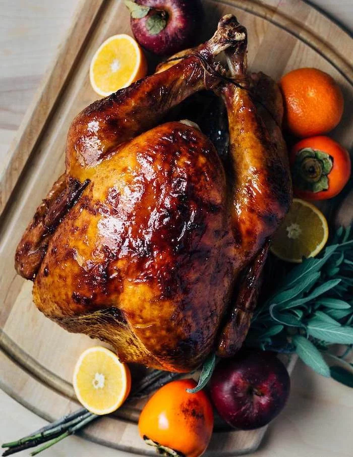 thanksgiving turkey recipe, roasted turkey, lemons and oranges, fresh herbs, on the side, wooden board