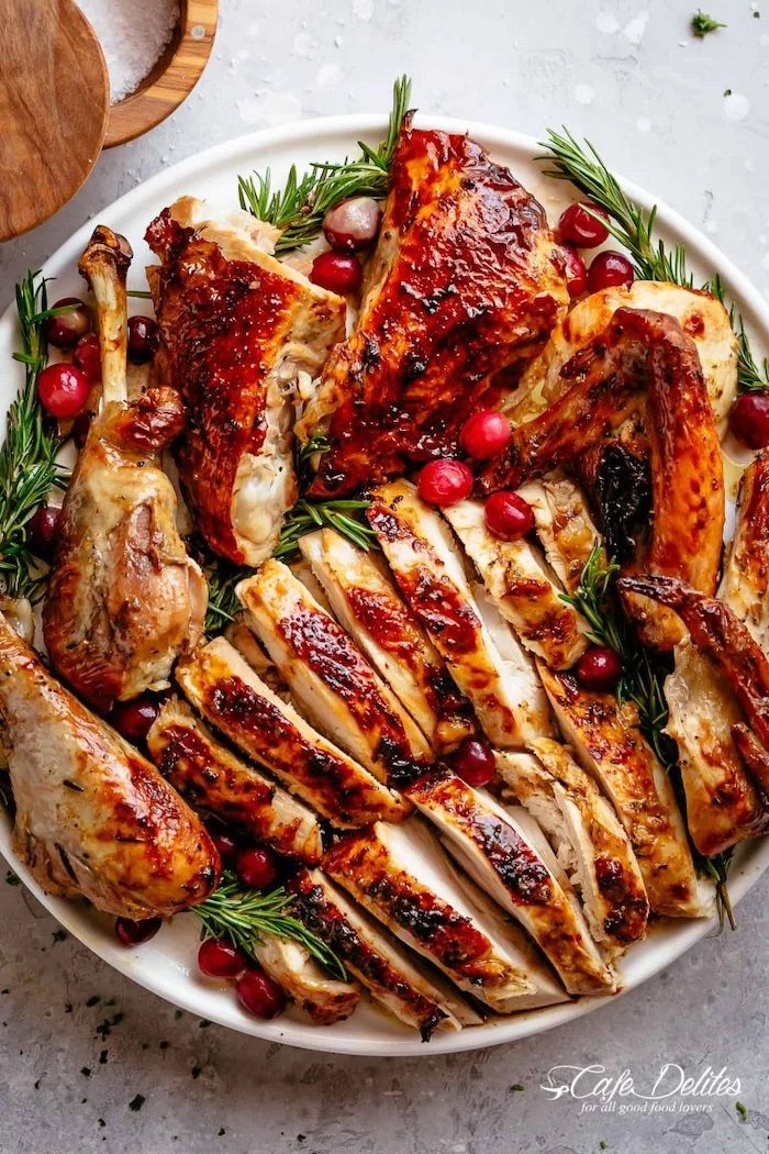 carved turkey, with cranberries, fresh rosemary, on the side, how long to cook a turkey, white plate, granite countertop