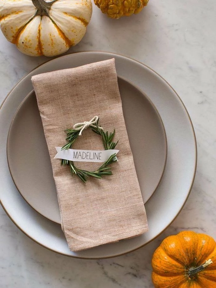 rosemary wreath, over napkin, madeline table setting, outdoor thanksgiving decorations, white plates, marble countertop