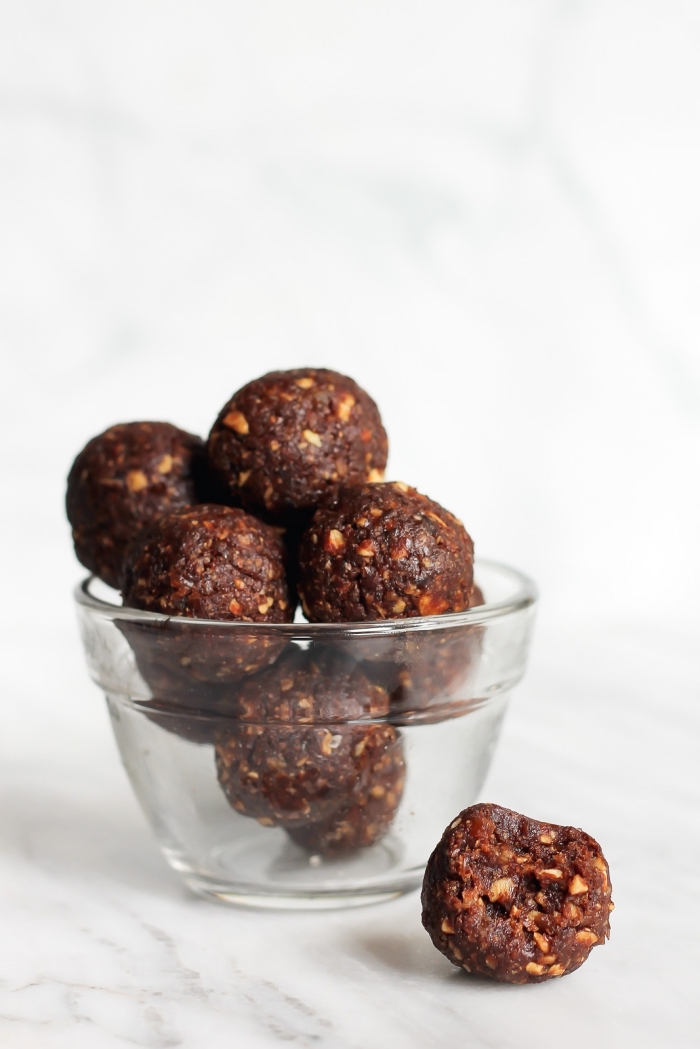 chocolate truffles, with nuts, in a glass bowl, white background, peanut butter oatmeal balls
