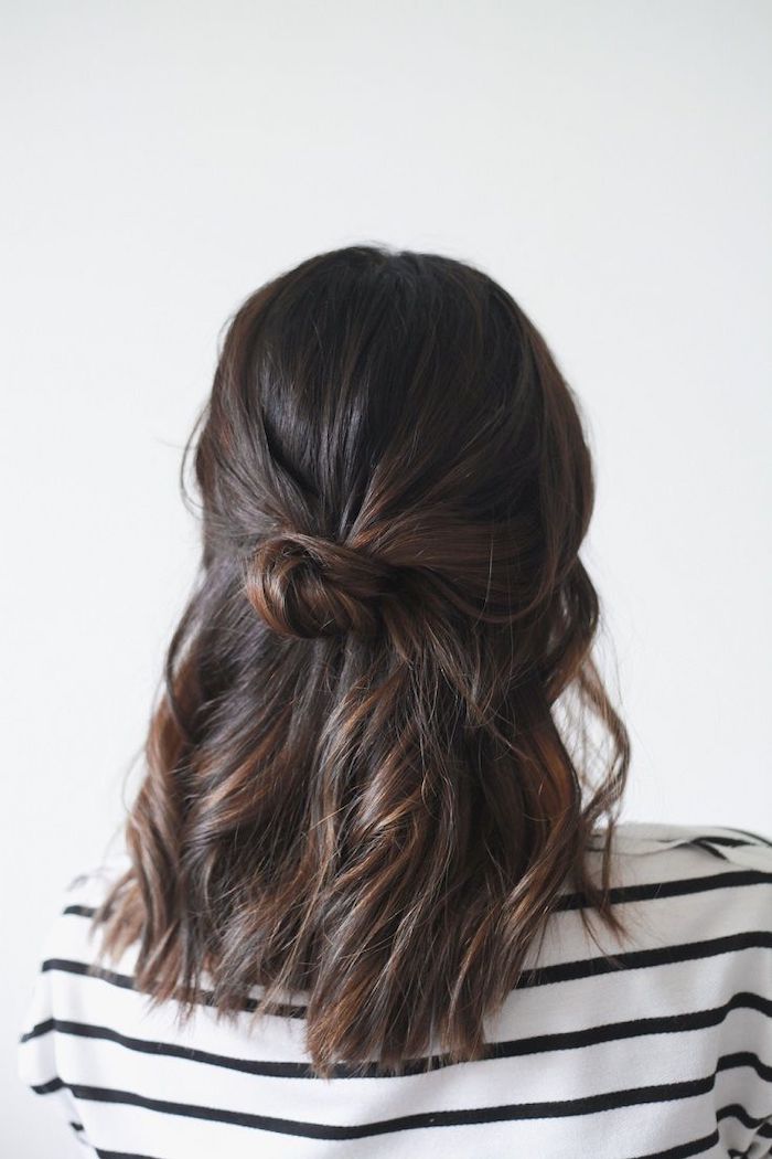 woman with dark brown, half up, wearing white and black striped blouse, shoulder length hairstyles, white background