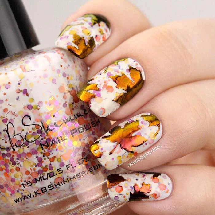 white nail polish, colorful glitter, watercolor fall leaves, nail decorations, neutral nail colors, nail polish bottle