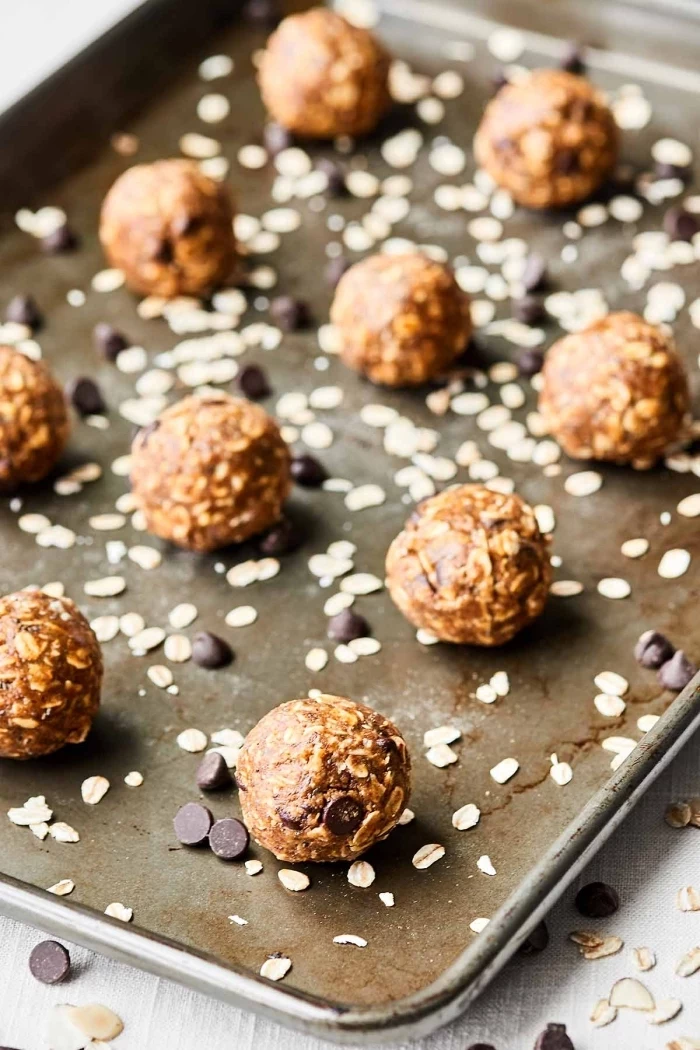 chocolate chips and oatmeal, scattered around, date energy balls, arranged in a sheet pan