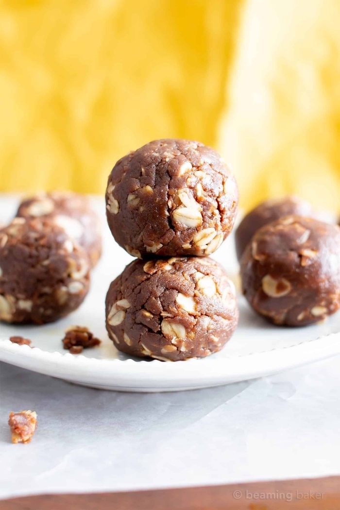 chocolate truffles, with peanuts, arranged on white plate, date energy balls, white baking paper