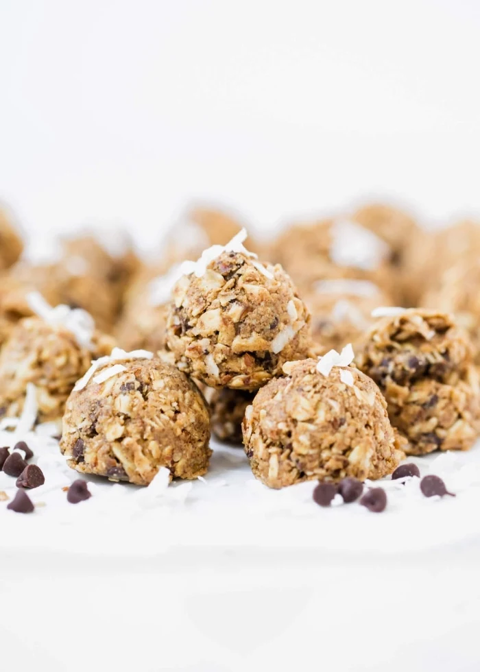 oatmeal balls, peanut butter oat balls, with chocolate chips, coconut flakes, on white table