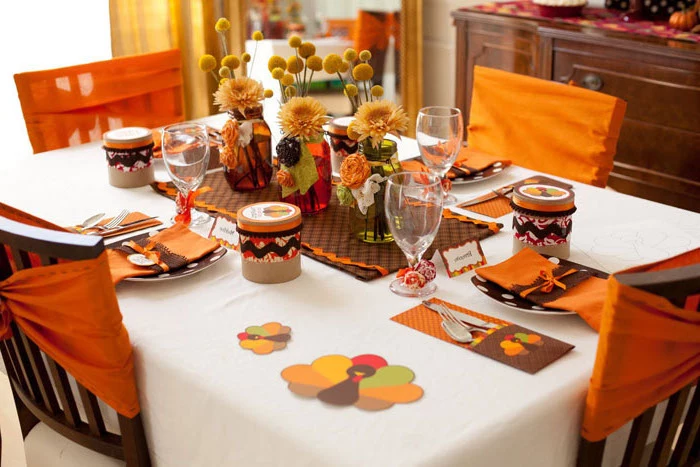 wooden chairs, orange ribbons on them, pinterest thanksgiving, flower bouquets, plate settings, white table cloth