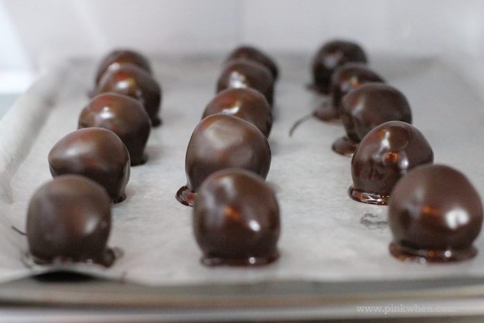 oreo cookie balls, covered with chocolate, arranged on baking paper, thanksgiving desserts ideas