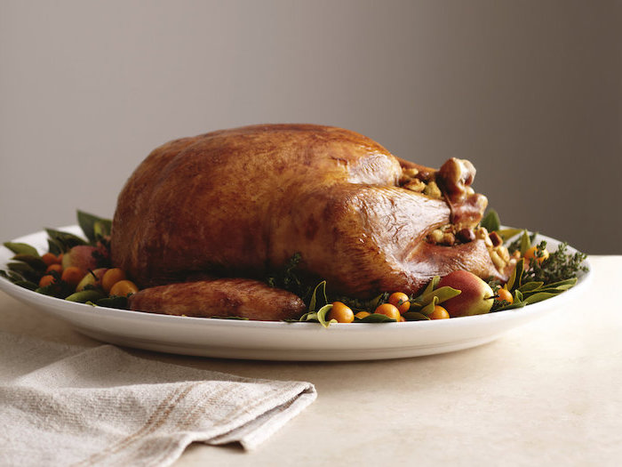 white background, roasted turkey, fresh herbs, cranberries on the side, how to prepare a turkey, white plate