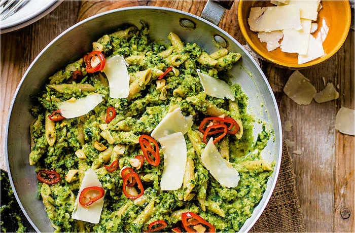 pasta with pesto, parmesan on top, sliced peppers, healthy meal prep ideas for weight loss, wooden table
