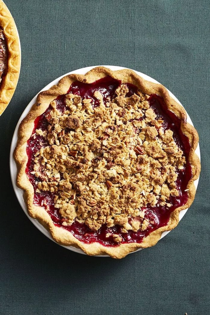 pear and blackberry pie, crushed nuts on top, white plate, dark grey cloth, thanksgiving cake ideas