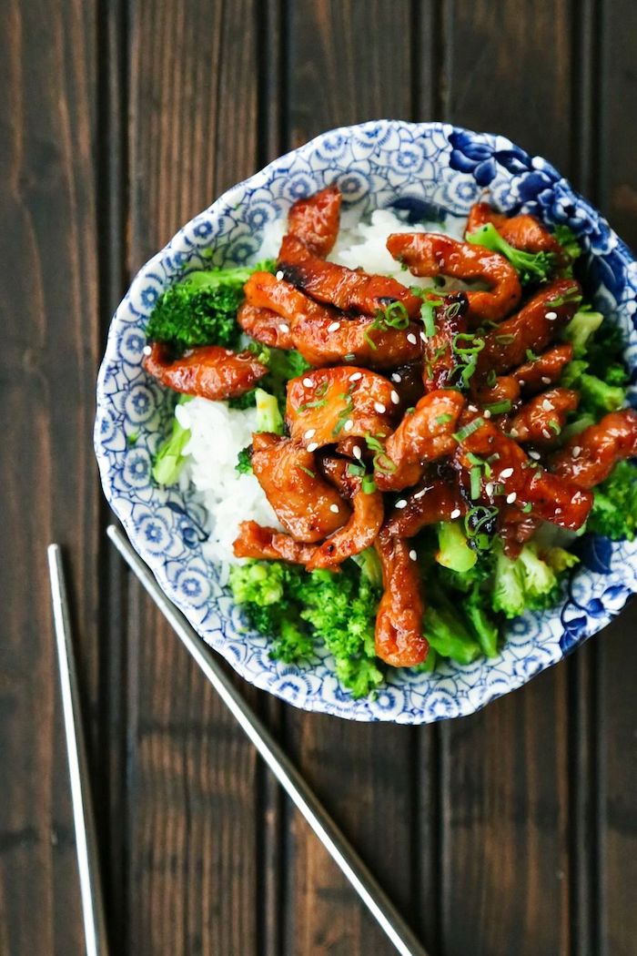 pork with sesame seeds, broccoli and rice, in blue ceramic bowl, what should i make for dinner, metal chopsticks, wooden table