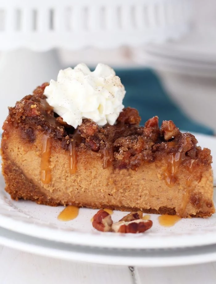 slice of cake, pecan cheesecake, thanksgiving dessert recipes, caramel drizzle, cream on top, white plate