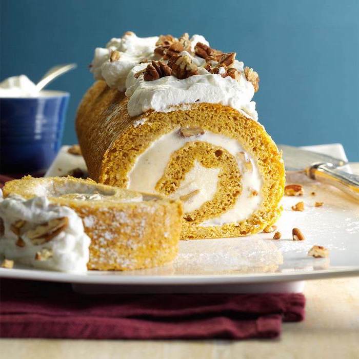 pumpkin pie roll, thanksgiving desserts for kids, cream and walnuts, powdered sugar, on top, white plate