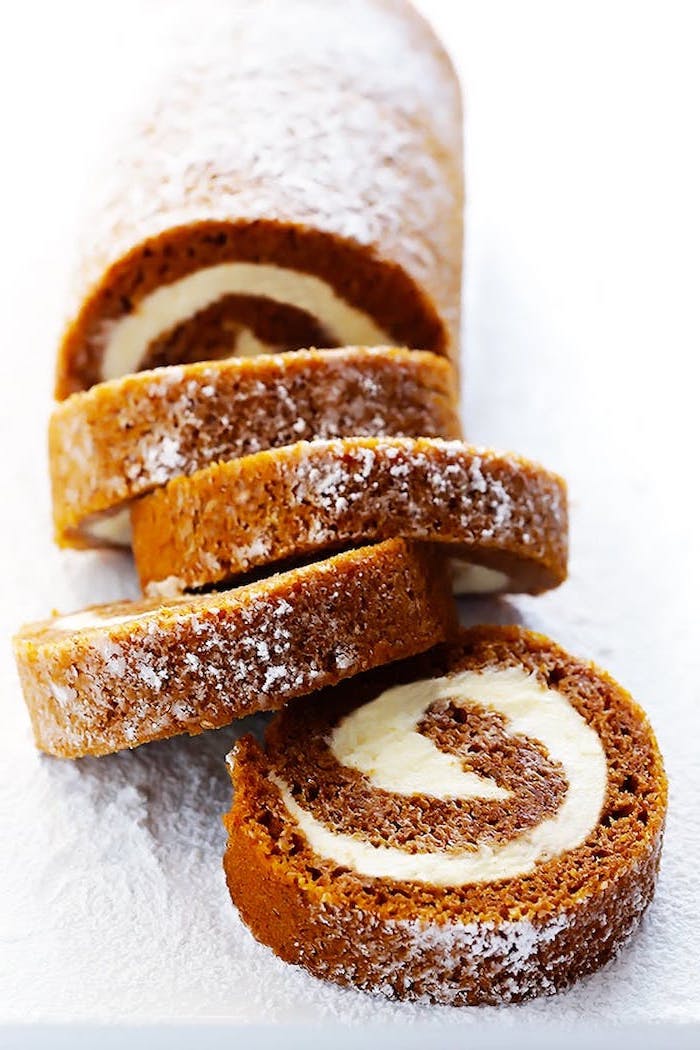 pumpkin pie roll, white frosting inside, thanksgiving desserts for kids, powdered sugar on top