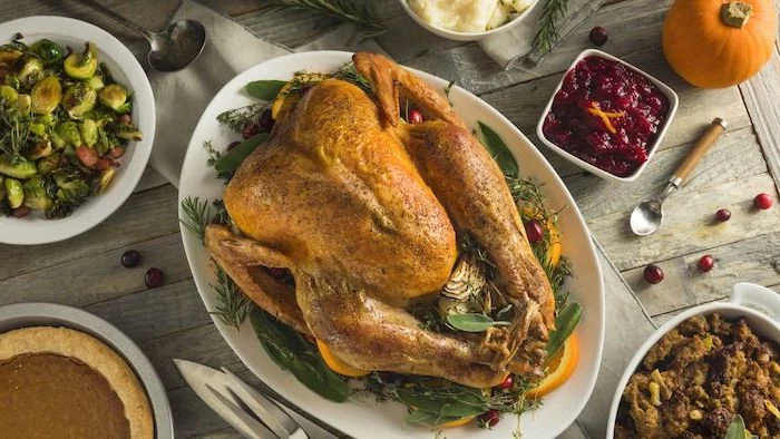 cranberry sauce, wooden table, roasted turkey, fresh herbs, lemon slices, on the side, how to cook a thanksgiving turkey