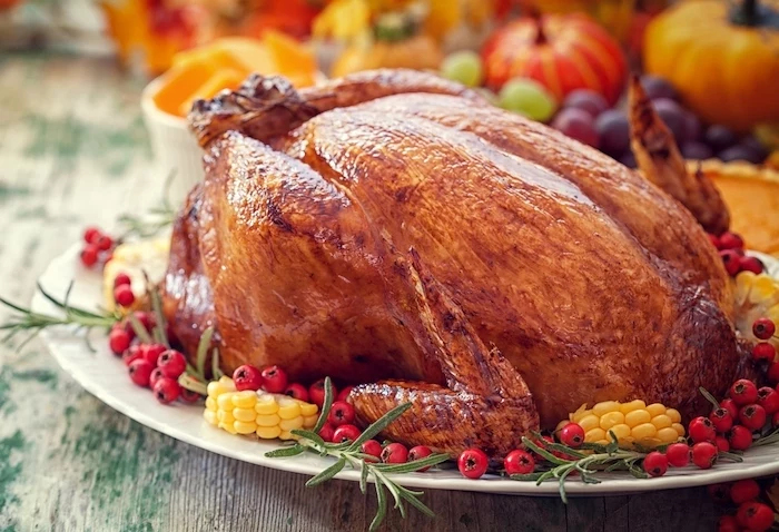 roasted turkey, corn and cranberries, on the side, how to cook a thanksgiving turkey, white plate, wooden table