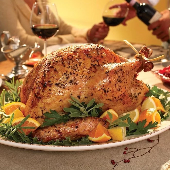 wine glasses, roasted turkey, fresh herbs, lemon slices, on the side, how to cook a thanksgiving turkey, white plate