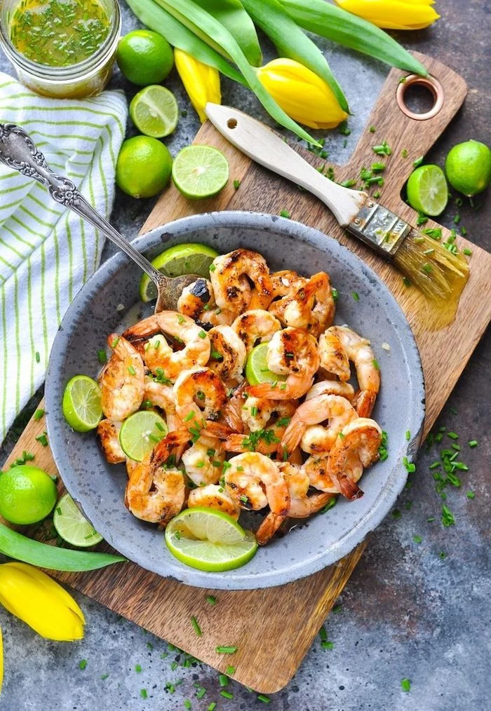 honey lime sauce, shrimp in a ceramic bowl, lime slices inside, low calorie meals, wooden cutting board