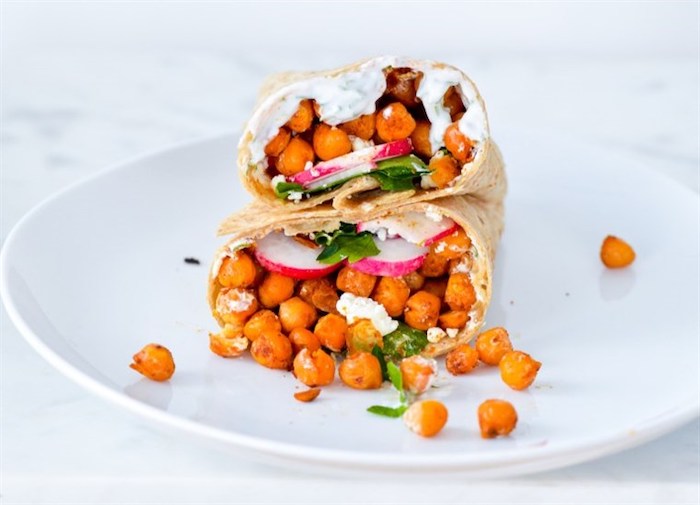 chickpea wrap, with turnip and parsley, yoghurt sauce, sliced in two, on white plate, healthy meal plans