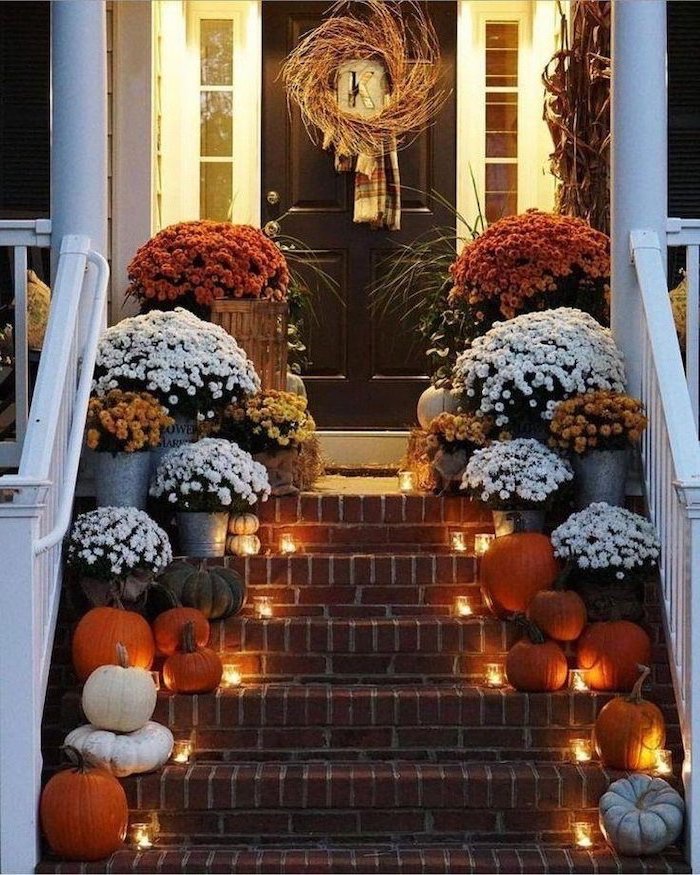 large flower bouquets, pumpkins and candles, arranged on each step, thanksgiving door decor, wreath on the door