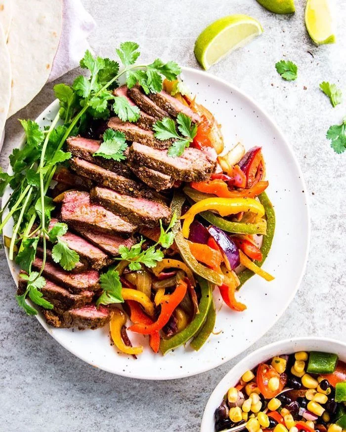 weight loss diet, steak fajitas, sliced peppers, parsley garnish, on white plate, lime slices, on the side