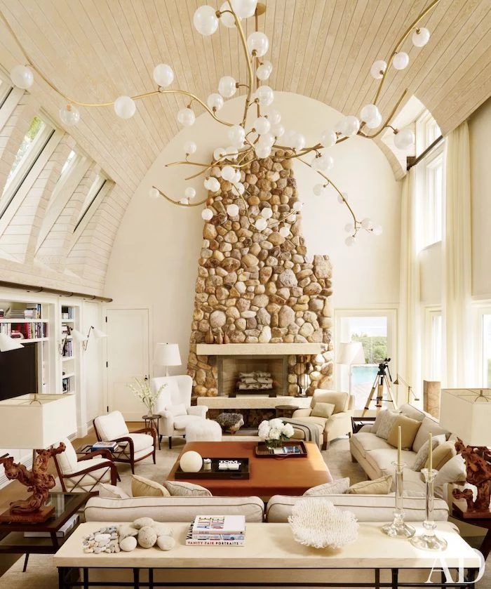 barrel ceiling, wooden ceiling with skylights, stone fireplace wall, vaulted ceiling lighting, hanging chandelier