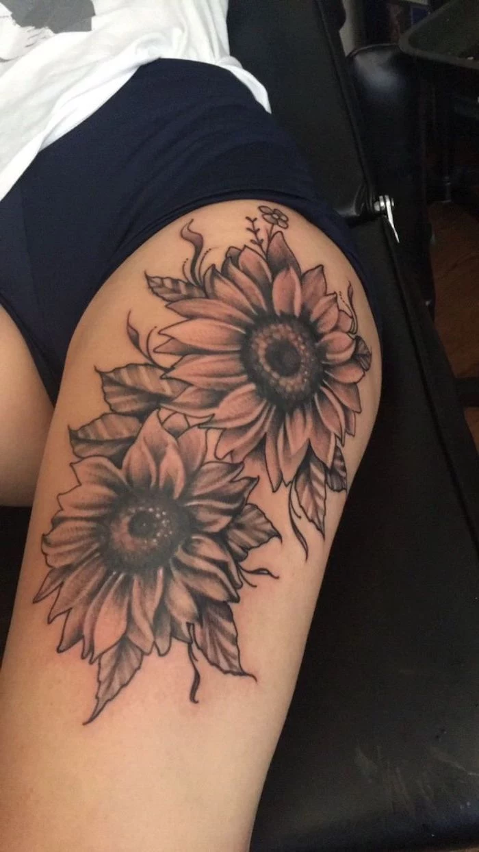 two sunflowers, upper thigh tattoo, black shorts, white t shirt, black leather bed