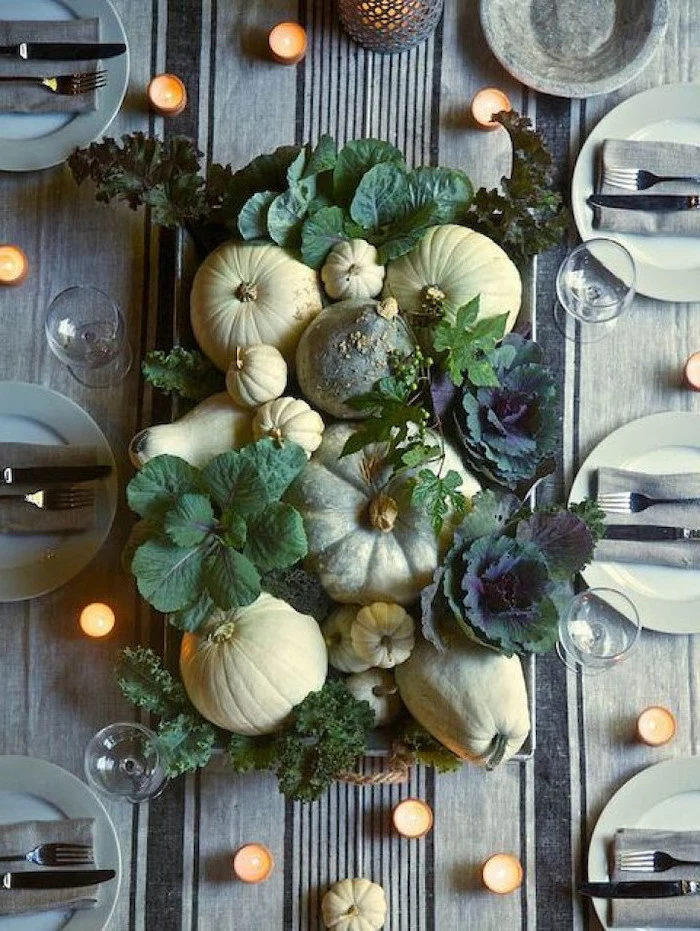 pumpkins and leaves, arranged in the middle of the table, thanksgiving home decorations, plate settings, candles everywhere
