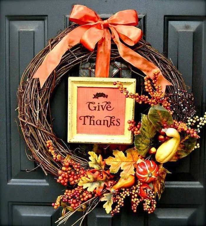 wooden wreath, with faux leaves and fruits, thanksgiving home decorations, black door, orange ribbon