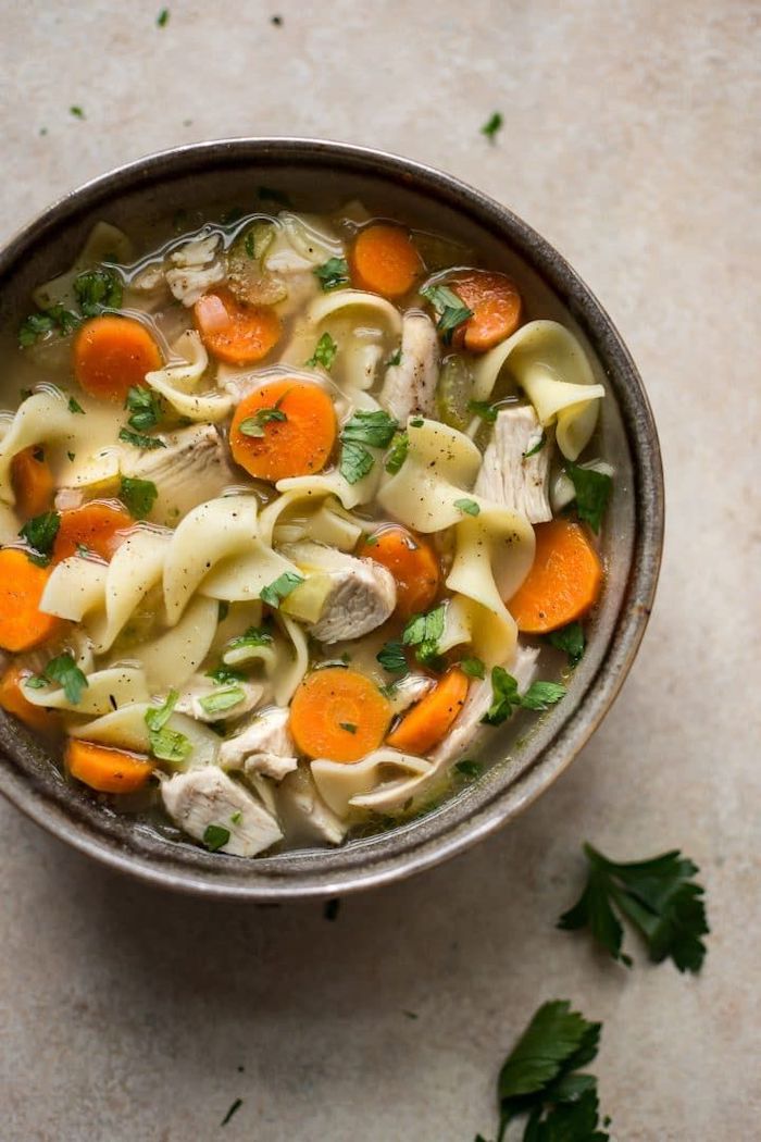 chopped carrots, parsley garnish, turkey noodle soup, in a ceramic bowl, healthy meal prep