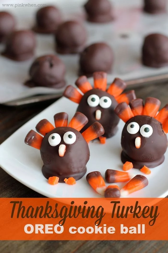 turkey shaped, oreo cookie balls, with candy corn, thanksgiving desserts ideas, white plate, wooden table