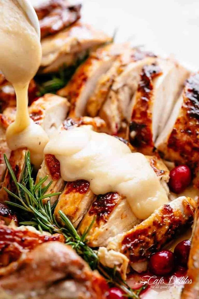 turkey slices, covered in gravy, cranberries and fresh rosemary, on the side, how long to cook a turkey