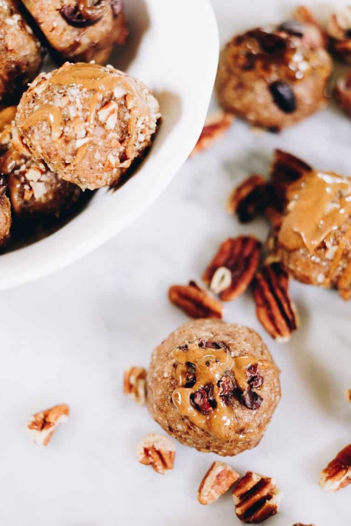 oatmeal bites, healthy energy balls, peanut butter drizzle on top, walnuts scattered around