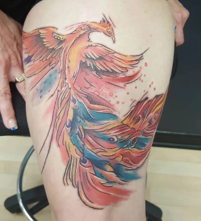 cute thigh tattoos, watercolor tattoo, large phoenix, wooden floor, black wall