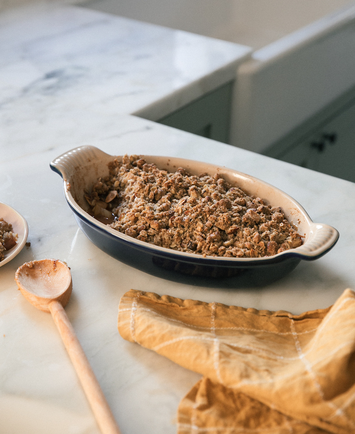 black white casserole, apple crumble, easy thanksgiving desserts, marble countertop, wooden spatula, orange cloth