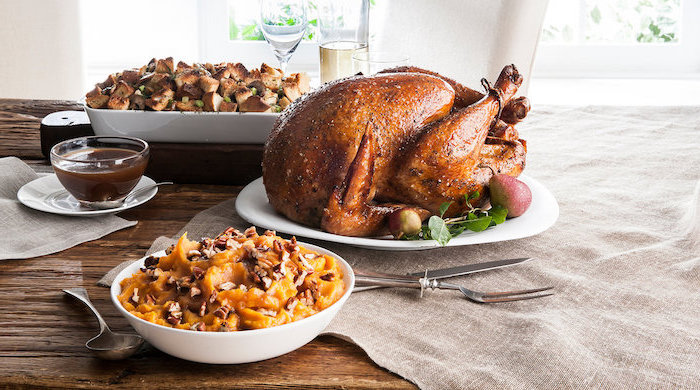 how to make a turkey for thanksgiving, wooden table, turkey stuffing, in white casserole, roasted turkey, white plate