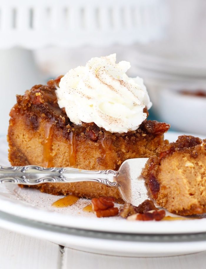 silver fork, white plate, thanksgiving dessert recipes, slice of cake, pecan cheesecake, caramel drizzle, cream on top