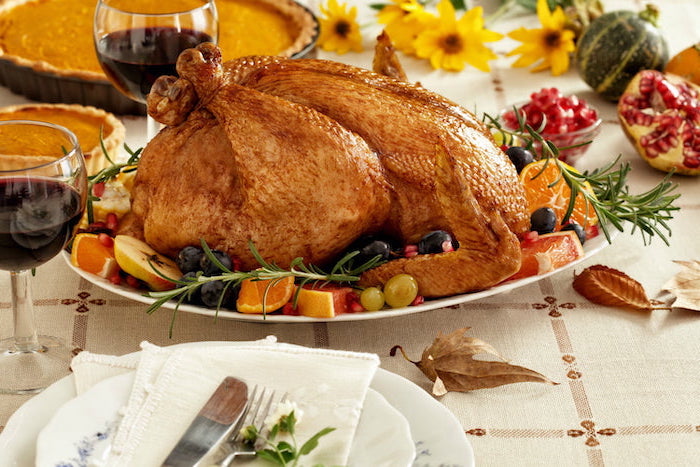 fresh rosemary, grapes and apples, orange slices, on the side, how to make a turkey for thanksgiving, white plates